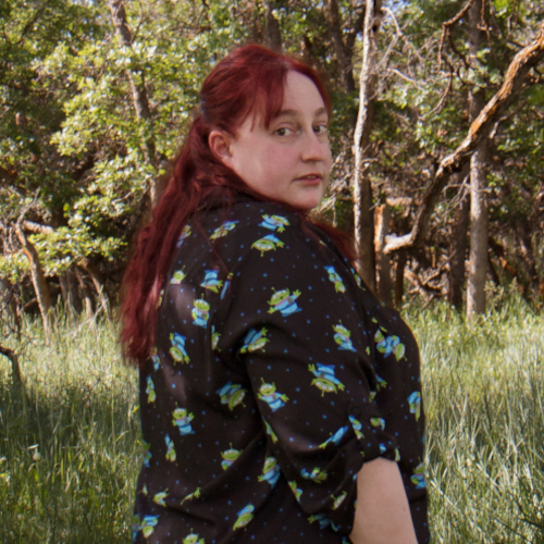 Lisa's profile wearing Pixar Aliens shirt in wooded area